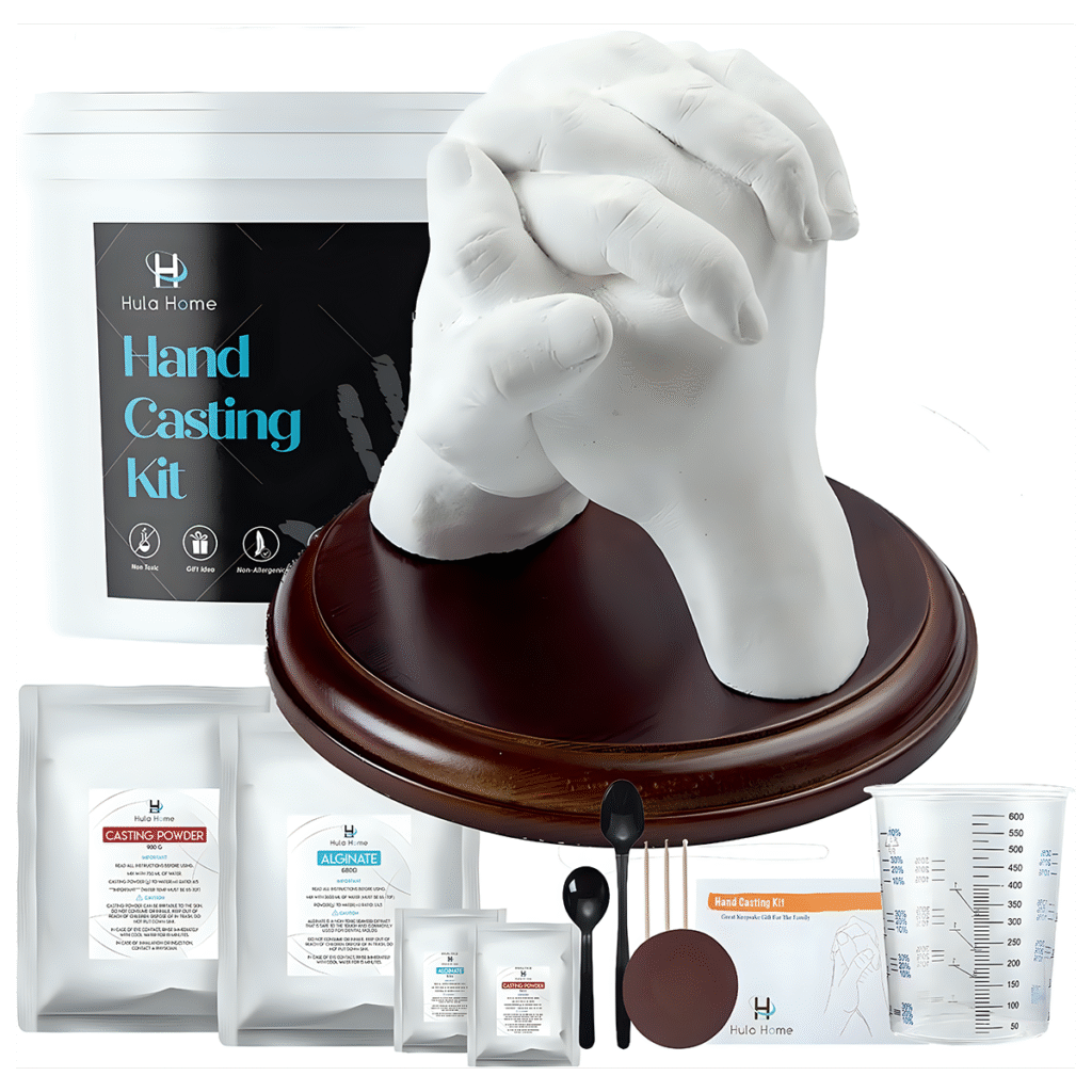 Ditch Netflix: Try These 20 Intimate Bedroom Dates 9 Product photograph of a "Hula Home Hand Casting Kit" showing a white plaster cast of clasped hands on a wooden display base, with the complete kit contents including casting powder, alginate, measuring tools, and instruction materials.