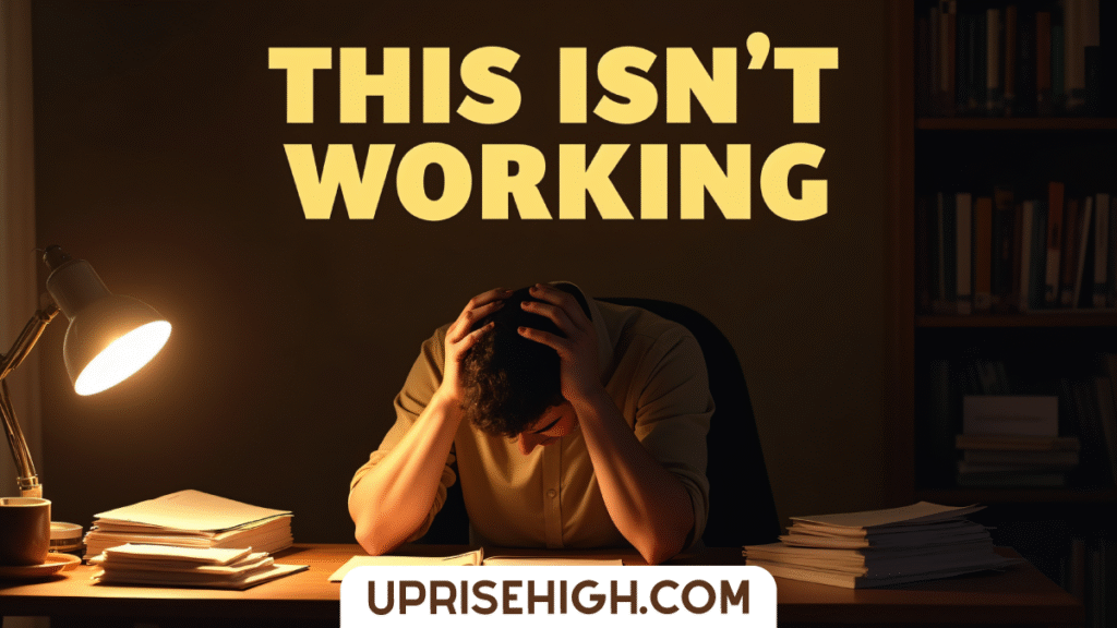 A frustrated person holds their head in their hands at a desk surrounded by books and papers, with "THIS ISN'T WORKING" text overlay in a dimly lit study.